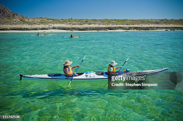 sea-kayaking in clear blue-green water - zeekajakken stockfoto's en -beelden