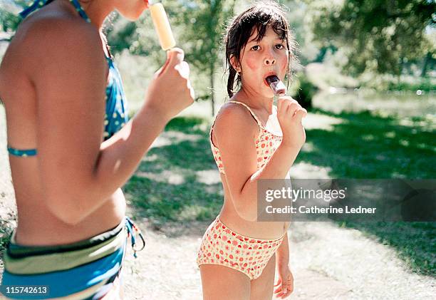 girl in bathing suit with a popsicle - tween girl swimsuit stockfoto's en -beelden