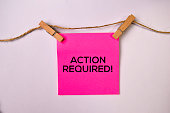 Action Required! on sticky notes isolated on white background.