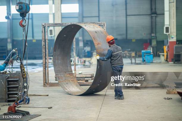 trabajador empujando un anillo de metal en fábrica - hoja de aluminio fotografías e imágenes de stock