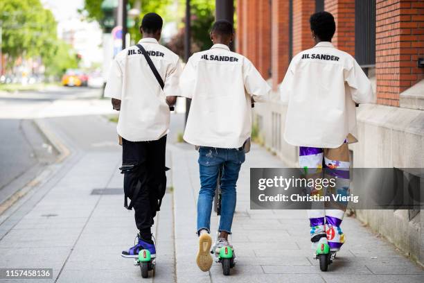 Models seen riding a Lime e-scooter outside Jil Sander during Paris Fashion Week - Menswear Spring/Summer 2020 on June 21, 2019 in Paris, France.