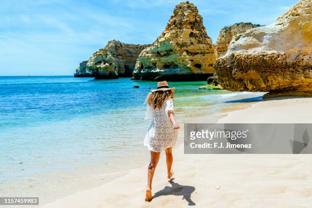 woman running in praia da marinha, the algarve - algarve fotografías e imágenes de stock
