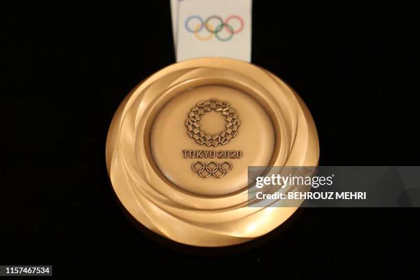 The bronze medal for the Tokyo 2020 Olympic Games is unveiled during a ceremony marking one year before the start of the games in Tokyo on July 24,...