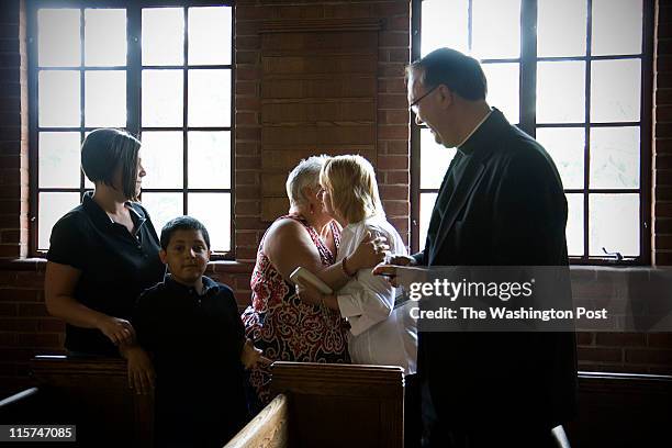 Rev. Mark Lewis, daughter Jodi Lewis and grandson Sherman Worrell watch as Ginny McKnew gives a hug to Vickey Lewis at St. LukeÕs Episcopal Parish....