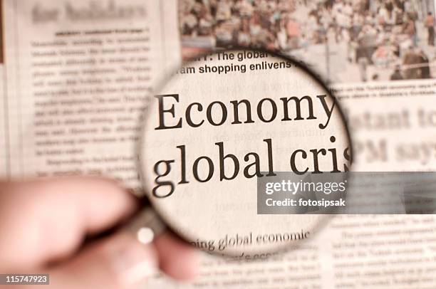 magnifying glass over a newspaper highlighting words - global media stockfoto's en -beelden