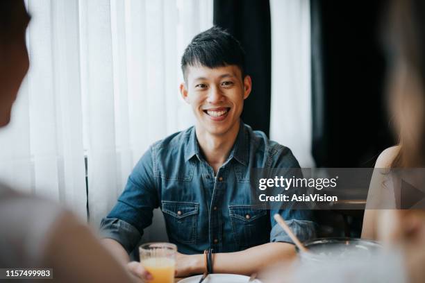 portret van glimlachende jonge aziatische man met plezier en genieten van eten en drinken in feest met vrienden - speed dating stockfoto's en -beelden