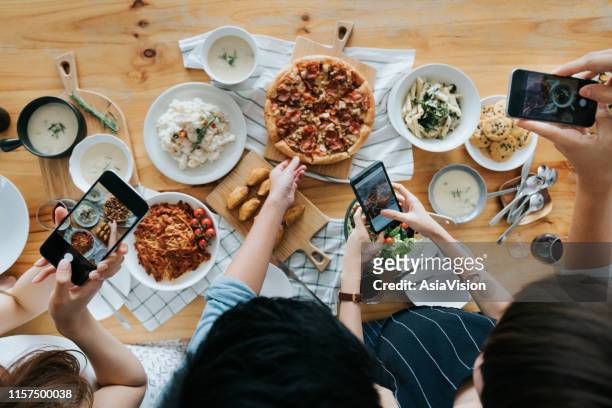 gruppe von freunden fotografieren essen auf dem tisch mit smartphones während der party - flat lay photography stock-fotos und bilder