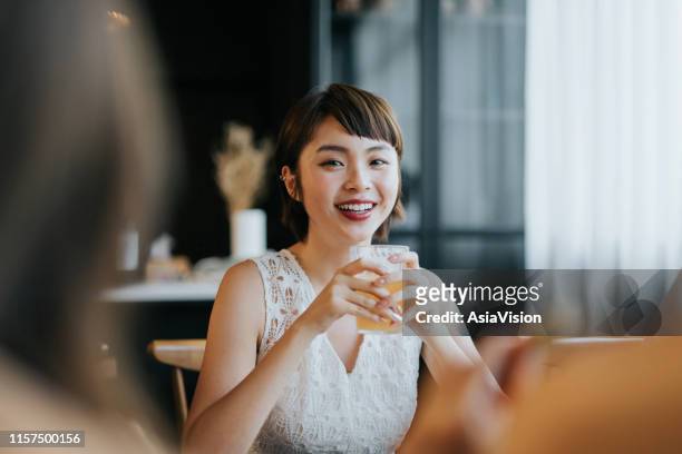 portrait of smiling young asian woman having fun and enjoying food and drinks in party with friends - single adults eating dinner at home stock pictures, royalty-free photos & images