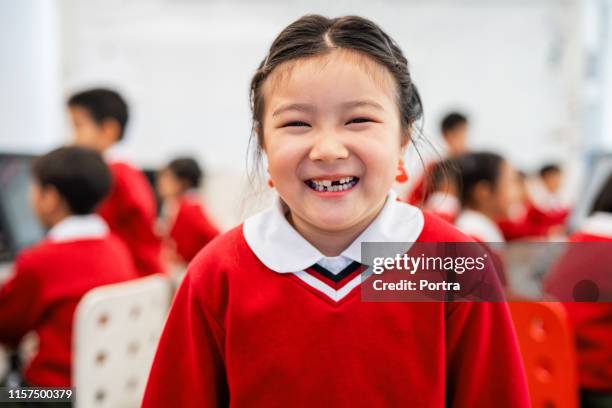 portrait of cheerful girl standing in computer lab - school sweater stock pictures, royalty-free photos & images