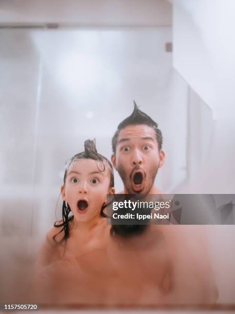 father and child making funny faces in bathroom - mirror steam stockfoto's en -beelden