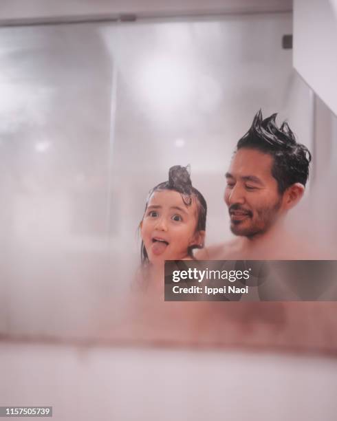 cute 4 year old child making a face in bathroom with father - mirror steam stockfoto's en -beelden
