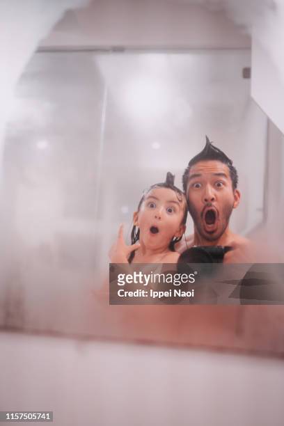 father and child making funny faces in bathroom - steamy mirror stock pictures, royalty-free photos & images