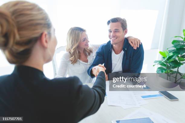 real estate agent met paar schudden handen sluiten van een deal. - self closing stockfoto's en -beelden