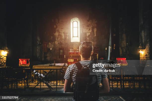 praying in ancient monastery - armenian church stock pictures, royalty-free photos & images