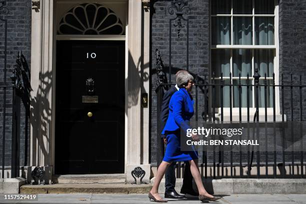 Britain's outgoing prime minister Theresa May,accompanied by her husband Philip, leaves after making a speech outside 10 Downing street in London on...