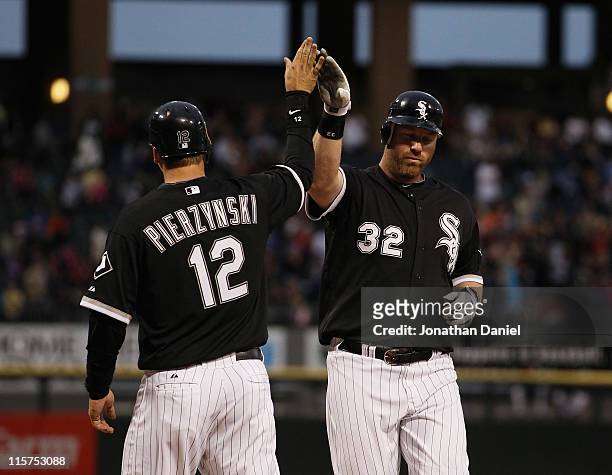 Adam Dunn of the Chicago White Sox is congratulated by teammate A.J. Pierzynski after hitting a two-run home run in the 3rd inning against the...