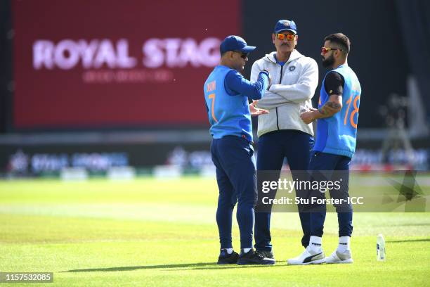 India captain Virat Kohli chats with coach Ravi Shastri and MS Dhoni before the Group Stage match of the ICC Cricket World Cup 2019 between India and...