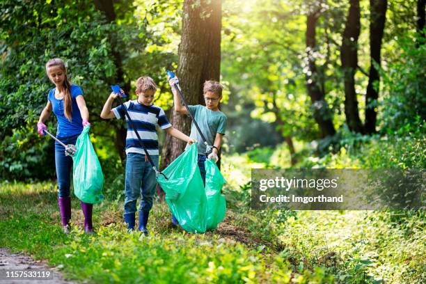 kids cleaning up the forest - volunteers cleaning public park stock pictures, royalty-free photos & images