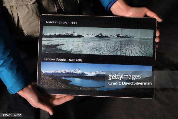 An Argentinian guide holds photographs showing how the Upsala glacier, part of the Southern Patagonian Ice Field, has receded in the past 90 years,...