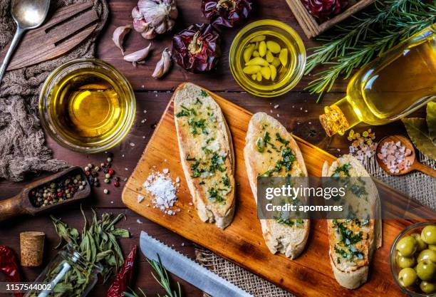 snack or appetizer of garlic basil and olive oil bruschetta on table in a rustic kitchen - table aperitif stock pictures, royalty-free photos & images