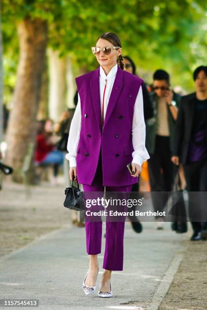 Olivia Palermo wears sunglasses, a purple sleeveless blazer jacket, a white shirt, purple pants, outside Berluti, during Paris Fashion Week -...