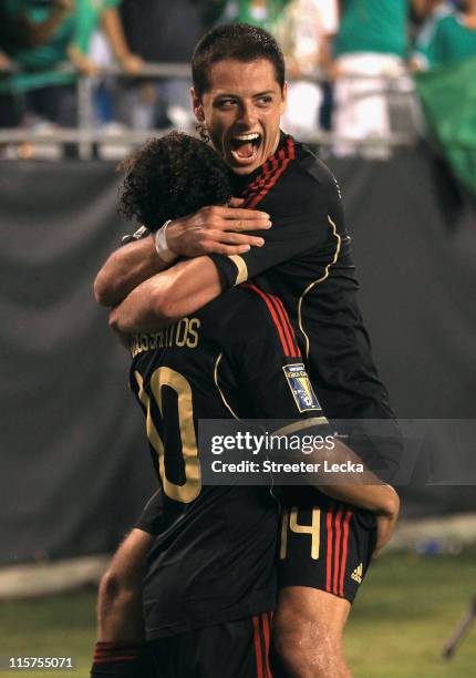 Javier Hernandez celebrates with teammate Giovani Dos Santos of Mexico after Dos Santos scored a goal against Cuba during their game in the CONCACAF...