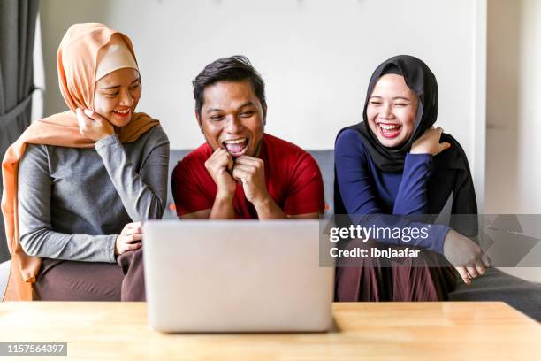 jonge mooie moslimfamilie met behulp van laptop - polygamie stockfoto's en -beelden