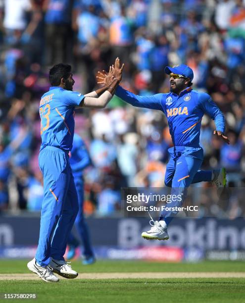 India bowler Jasprit Bumrah celebrates with Kedar Jadhav after catching Afghanistan batsman Hashmatullah Shaidi off his own bowling during the Group...