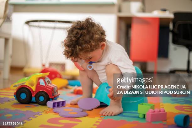 baby boy spelen - plaspot stockfoto's en -beelden