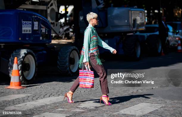 Elisa Nalin is seen wearing striped bag, heesls, brown pants, green top with fringes outside Sacai during Paris Fashion Week - Menswear Spring/Summer...