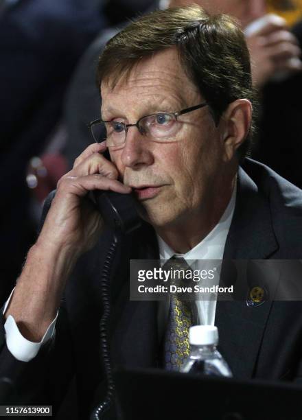 General manager David Poile of the Nashville Predators talks on the phone at the team draft table during Rounds 2-7 of the 2019 NHL Draft at Rogers...