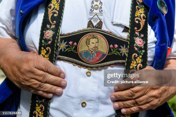 June 2019, Bavaria, Berg: Anton Steinböck, vice chairman of the Königstreuen in Augsburg, wears a portrait of King Ludwig II on his suspenders during...