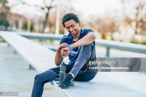 sportsman checking his smart watch - pedometer stock pictures, royalty-free photos & images