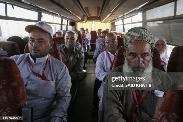 Palestinian Muslim pilgrims sit in a bus at the Rafah border crossing between the Gaza Strip and Egypt on July 25 as pilgrims wait to cross into...