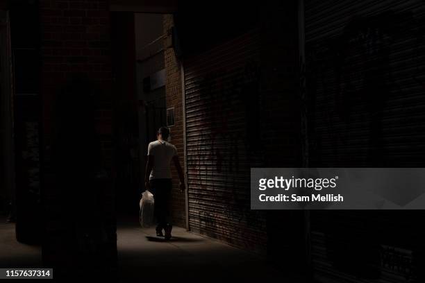 Man walking between the shadows at Brixton Railway Station as temperatures reach the low 30's across the capital on the 24th July 2019 in South...