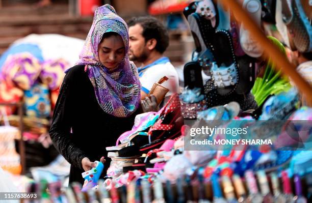 Muslim woman shops on a roadside market on the old quarters of New Delhi on July 25, 2019. - The ruling Bharatiya Janata Party government has listed...