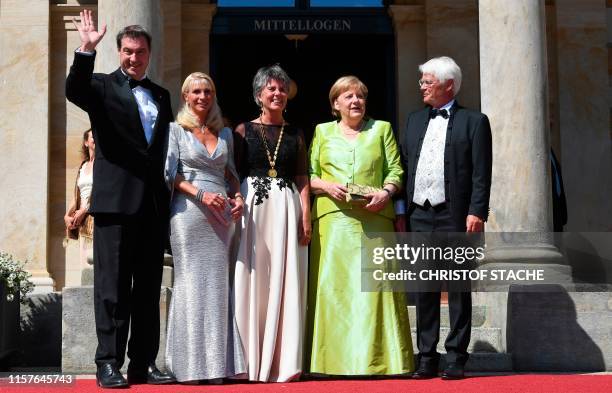 German Chancellor Angela Merkel poses with the mayor of Bayreuth Brigitte Merk-Erbe , her husband Thomas Erbe , Bavaria's State Premier Markus Soeder...