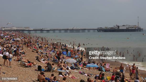 Beachgoers relax on a packed Brighton Beach on July 25, 2019 in Brighton, United Kingdom. The Met Office issued a weather warning from 3pm this...