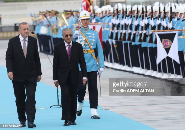 Turkish President Recep Tayyip Erdogan and Malaysian Prime Minister Mahathir Mohamad review the guards of honour during an official welcoming...
