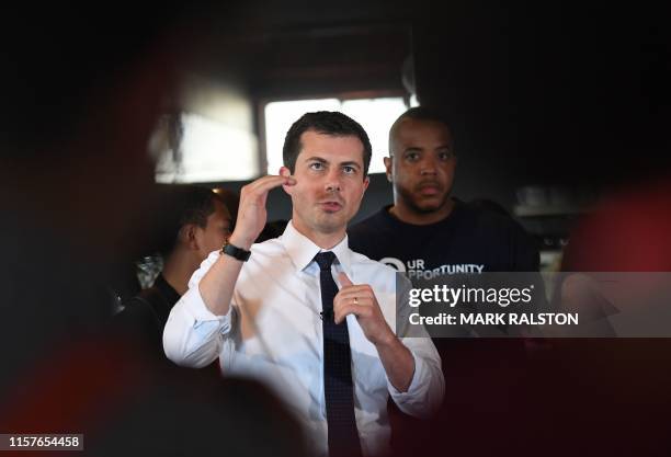 Democratic presidential hopeful and South Bend, Indiana mayor Pete Buttigieg speaks to the media beside David Gross during his tour of the Vector 90...