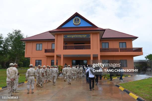 Cambodian navy personnel accompany journalists on arrival at Ream naval base in Preah Sihanouk province during a government organized tour on July...