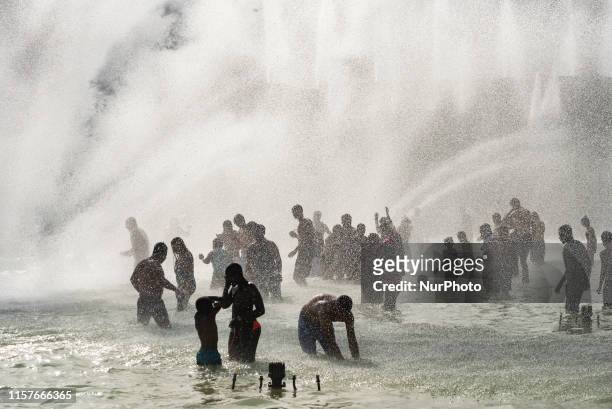 Many Parisians and tourists bathe under the many fountains of the Trocadero fountain to cool down as Paris and France as a whole go through their...