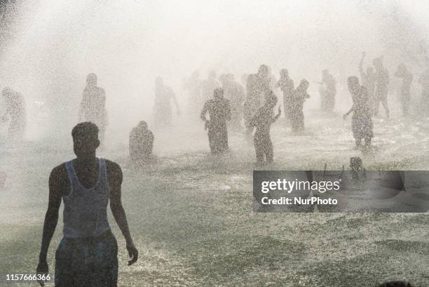 Many Parisians and tourists bathe under the many fountains of the Trocadero fountain to cool down as Paris and France as a whole go through their...