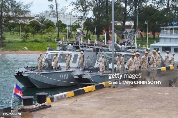 Cambodian navy personnel stand in formation on boats berthed at a jetty in Ream naval base in Preah Sihanouk province during a government organized...