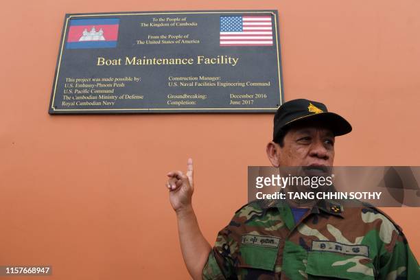 Cambodia's Ministry of Defense spokesperson Chhun Socheat shows a sign donated by the US during a government organised media tour to the Ream naval...