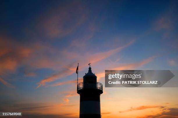 Picture taken on July 25, 2019 at sunset shows a lighthouse on the shore of the North Sea in Cuxhaven, northern Germany.