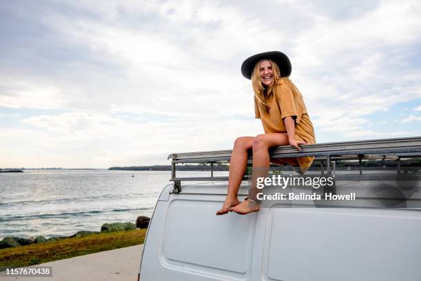 woman travelling solo with her van and her surfboard by the australian sea - australia travel stock pictures, royalty-free photos & images