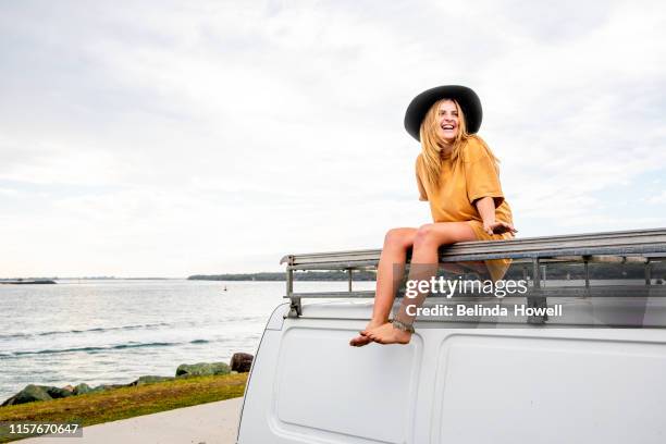 woman travelling solo with her van and her surfboard by the australian sea - one young woman only foto e immagini stock