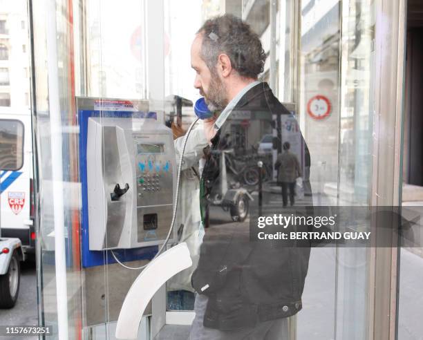 Photo prise le 05 octobre 2007 sur la place de la bourse à Paris, d'une personne téléphonant dans une cabine publique. Les cabines téléphoniques...