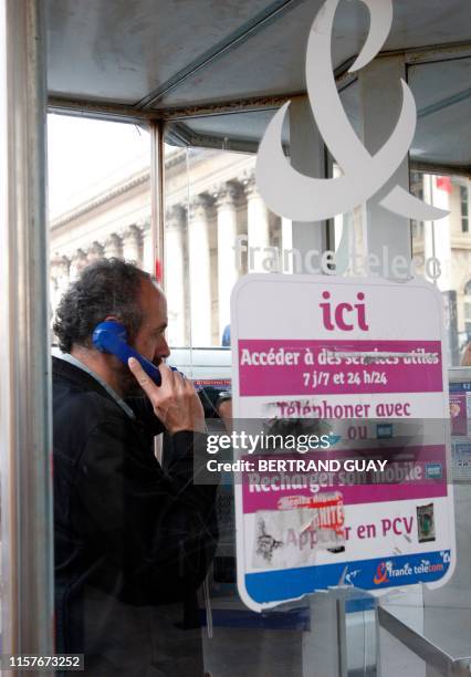 Photo prise le 05 octobre 2007 sur la place de la bourse à Paris, d'une personne téléphonant dans une cabine publique. Les cabines téléphoniques...